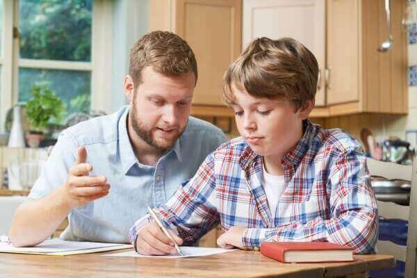 Young male tutor teaching young boy